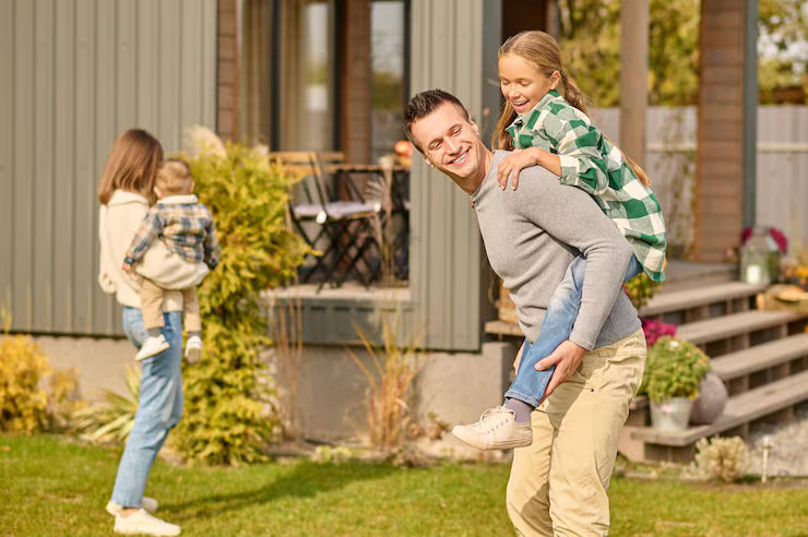 Family of four enjoying a day outdoors in front of a house.